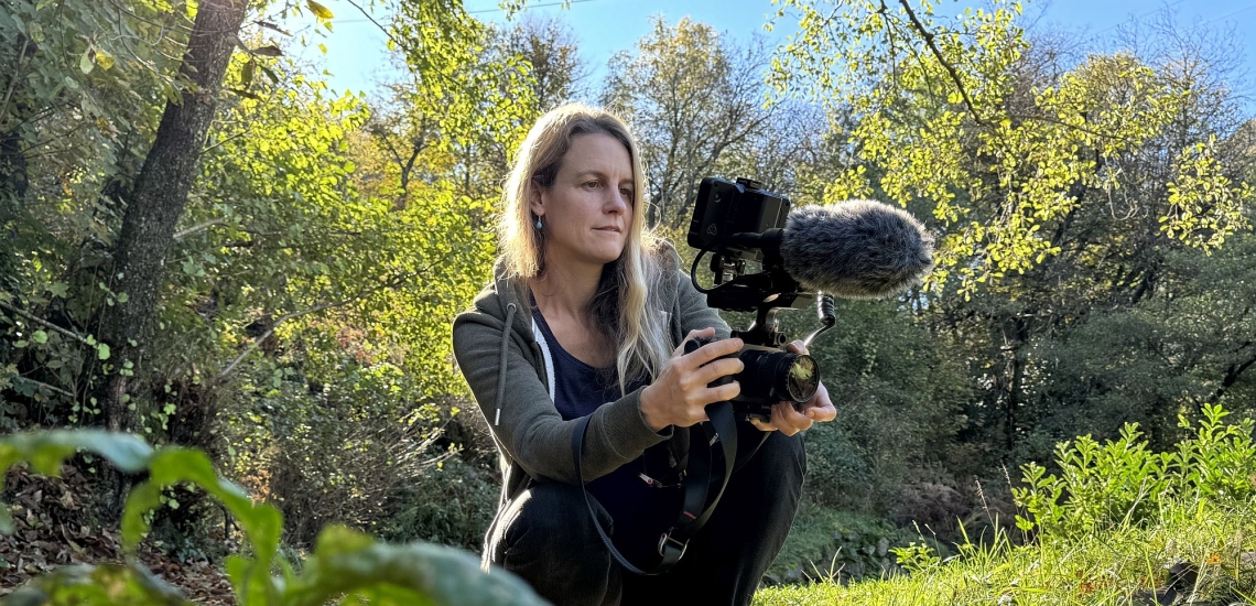 Isabella Sedivy mit Filmkamera draußen in der Natur